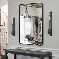 a mirror hanging on the wall above a table