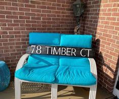 a blue chair sitting in front of a brick wall