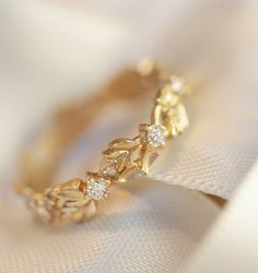 a gold ring with leaves and diamonds on it