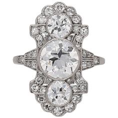 an antique style diamond ring with three oval cut diamonds in the center and two smaller round stones on each side