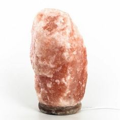 a pink rock sitting on top of a wooden base