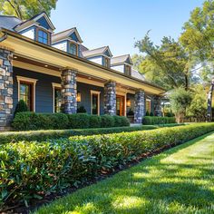 a house that has hedges in front of it and some bushes around the yard area