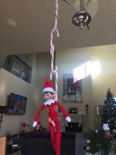 an elf is hanging from the ceiling with candy canes