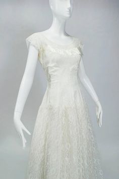 a mannequin wearing a white dress on display