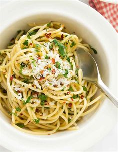 a white bowl filled with pasta and topped with parmesan cheese