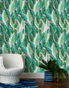 a white chair sitting on top of a wooden floor next to a green leafy wallpaper