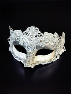 The cracked brocade lace design adds a touch of sophistication and the jewels are carefully placed to catch the light and enhance your beauty. Securely and comfortably fits every face shape so you can enjoy a perfect evening at the masquerade ball. Age Group/Gender - Adult/Women Size/Type - One size fits all adults Mask Color - Silver Mask Material - Polyresin/Fabric Accent Material - Gems Elegant White Masquerade Mask For Carnival, Elegant White Masquerade Mask For Mardi Gras, Elegant Silver Eye Mask, Elegant White Eye Mask, Formal Venetian Eye Mask For Masquerade, Silver Formal Masquerade Mask For Carnival, Elegant Adjustable Masquerade Mask For Mardi Gras, Venetian Style Formal Eye Masquerade Mask, Vintage Masquerade Mask For Carnival Party