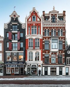 several buildings are lined up on the street in front of each other with windows and shutters