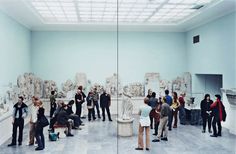 a group of people standing around in a room with statues on the walls and ceilings