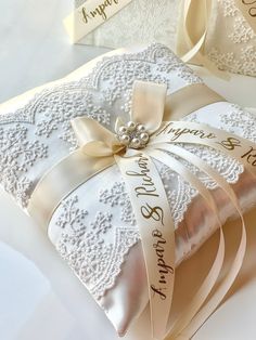 the wedding ring pillow is decorated with lace and satin ribbon, which reads happily married