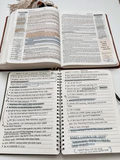 an open bible on top of a table next to a cup of coffee and pen