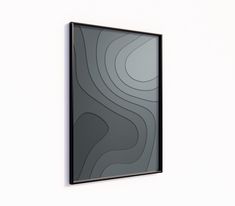 a black framed art piece hanging on the side of a white wall with wavy lines