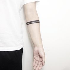 a person with a tattoo on their arm holding onto another persons hand and wearing a white t - shirt