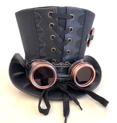 Steampunk Madhatter Hand made Black/white pinstripes suit fabric contrast with leather look fabric Top Hat with copper goggles and copper blank bullets as decor  Please refer to the photos. The hat is lined with black satin. back is Corseted Details With black Band Around the base of the hat with Antique brass buckle  Available in57,58,59 60,61cm Please note any markings / traces of glue are characteristics of the fabric and not a defect  Please note:- Even though there is a choice of sizes, the Black Punk Top Hat For Costume Party, Black Punk Style Top Hat For Costume Party, Punk Black Top Hat For Costume, Black Adjustable Top Hat For Costume Party, Black Steampunk Hat For Cosplay, Black Steampunk Hats And Headpieces For Cosplay, Black Steampunk Costume Hats And Headpieces For Cosplay, Black Steampunk Costume Hats For Cosplay, Black Fitted Punk Costume Hats And Headpieces