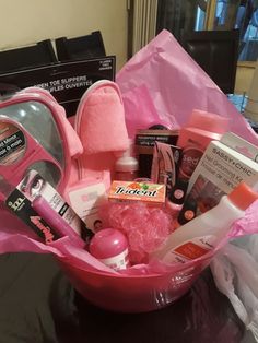 a pink basket filled with lots of beauty items on top of a black countertop