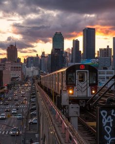 a train traveling through a city under a cloudy sky