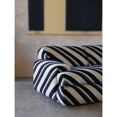 a black and white striped couch sitting in front of a painting