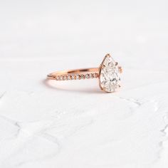 an oval shaped diamond ring with pave set diamonds on the band