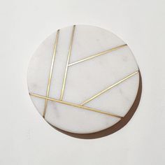 a white marble plate with gold lines on it's side, against a white background