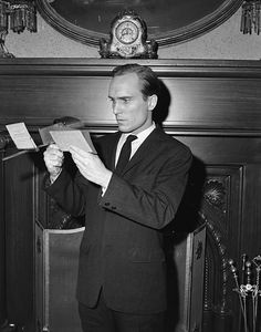 a man in a suit and tie is reading a piece of paper