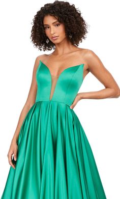 a woman in a green dress with her hands on her hips and one hand on her hip