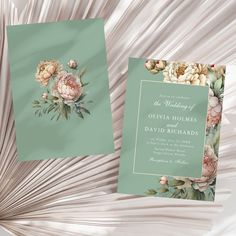 two wedding cards with flowers and leaves on the front, one is green and the other is pink