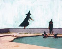 two people in witches hats jumping into a pool