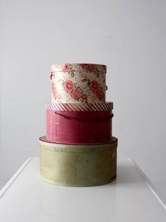 three stacks of different colored ribbons sitting on top of each other in front of a white wall