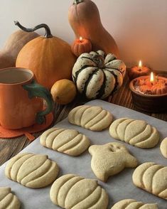 some cookies are on a cookie sheet next to pumpkins, candles and other decorations