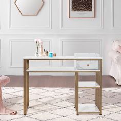 a living room with white walls and pink furniture, including a gold console table in the middle