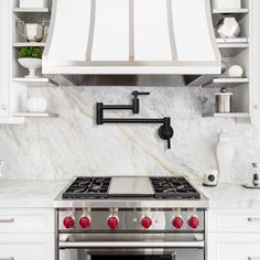 a stove top oven sitting inside of a kitchen next to white cabinets and counter tops