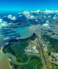 an aerial view of the city and its surrounding water, clouds, and landforms