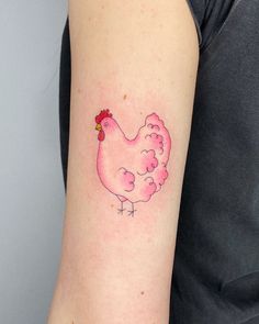 a small pink chicken tattoo on the arm