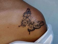 a woman's shoulder with flowers and a butterfly on it