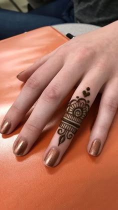 a woman's hand with henna tattoos on it