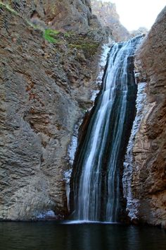 a large waterfall in the middle of a canyon