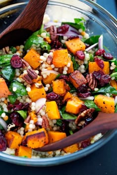 a salad with carrots, spinach, corn and cranberries in it