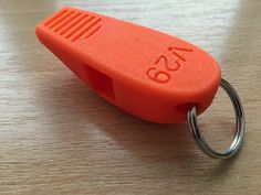 an orange plastic keychain on a wooden table