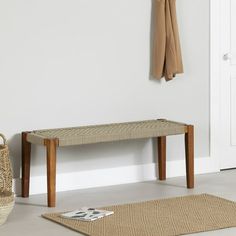 a wooden bench sitting next to a white door with a basket on top of it