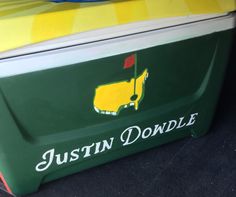 the back end of a green and yellow cooler with a golf flag on it's side