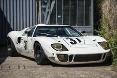 a white race car parked in front of a building