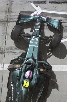 an overhead view of a racing car on the ground with its front wheels still in position