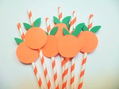 orange and white striped straws with paper fruit on them