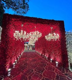 an elaborate red carpet with chandeliers and flowers on it for a wedding ceremony