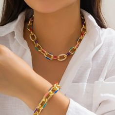 Chromatic Links Necklace & Bracelet Set The Chromatic Links Set consists of a necklace and bracelet duo, each featuring bold, oversized gold-tone links interspersed with enamel-coated links in a variety of vibrant hues. This colorful array includes rich purples, blues, reds, and greens, lending a playful yet chic edge to the classic chain link design. The substantial size of the links makes a definitive statement, while the bright colors add a touch of fun and are versatile enough to coo... Kalung Choker, Colorful Choker, Green Pendant Necklace, Colorful Bohemian, Choker Style Necklace, Neck Accessories, Party Necklace, Fashion Jewelry Sets, Choker Style