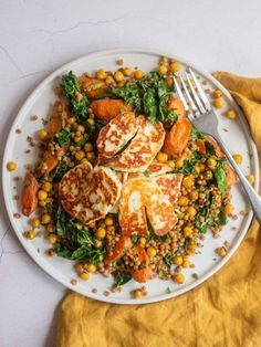 a white plate topped with chicken, carrots and chickpea couscous