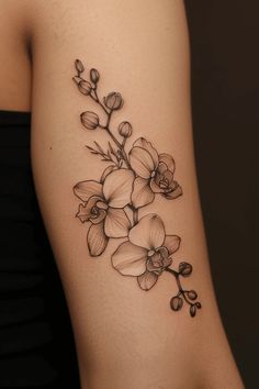 a black and white tattoo with flowers on the side of a woman's arm