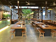 an empty restaurant with wooden tables and benches