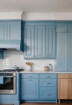 a kitchen with blue cabinets and wooden floors