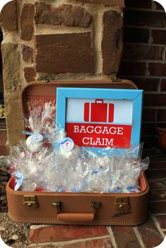 an open suitcase filled with plastic bags next to a sign that says baggage claim on it